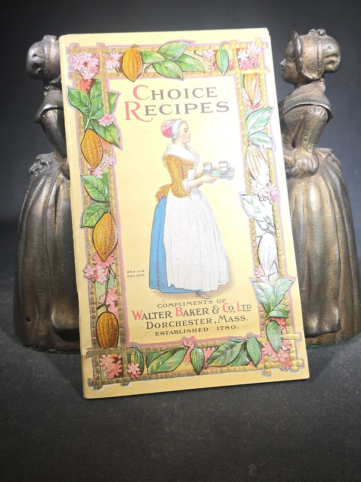 Pair of Antique Cast Iron Advertising Bookends and "Choice Recipes" Booklet, Walter Baker & Co. Ltd., Dorchester, Massachusetts, "La Belle Chocolatiere" Chocolate Maid Figure
