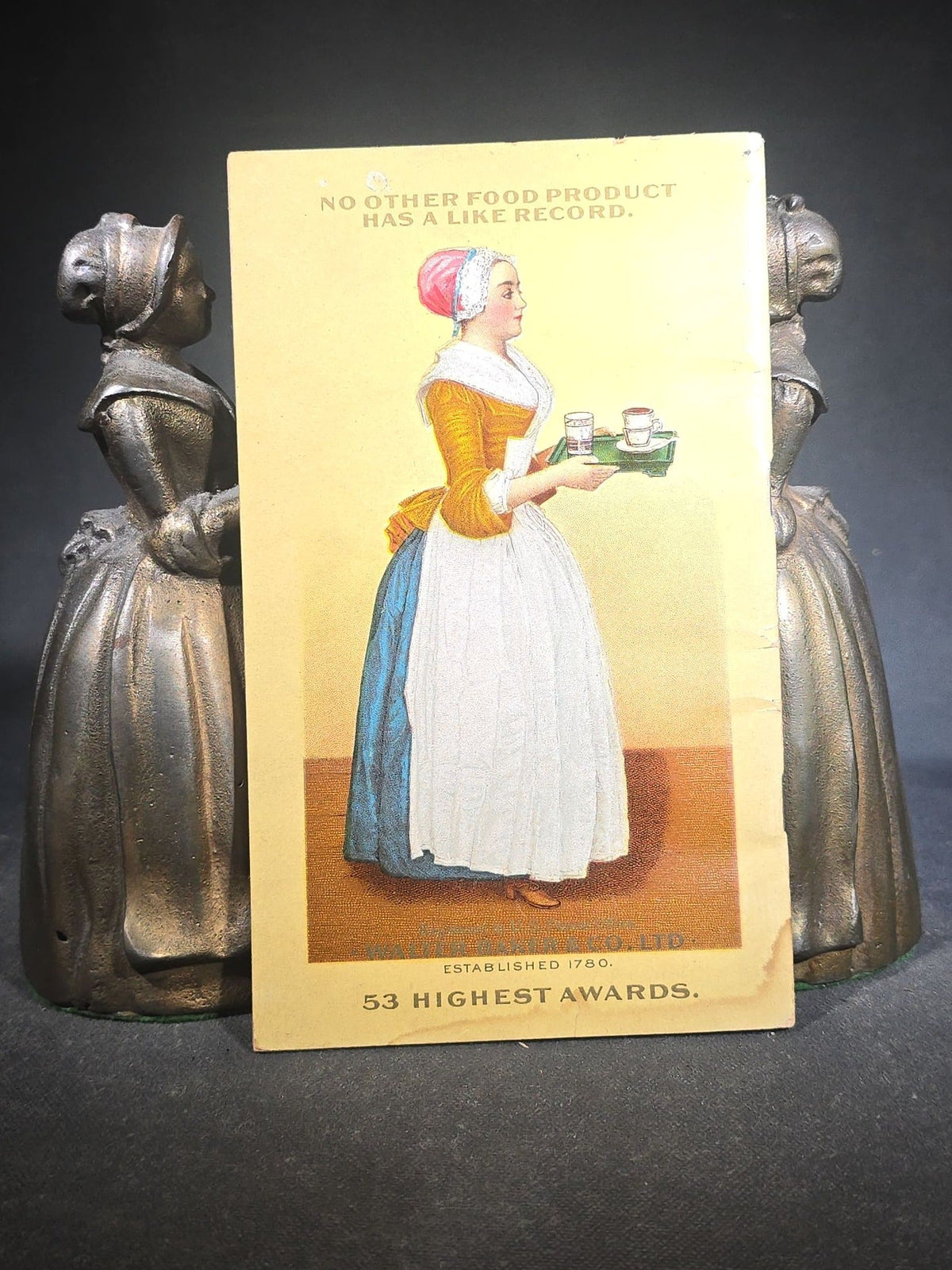 Pair of Antique Cast Iron Advertising Bookends and "Choice Recipes" Booklet, Walter Baker & Co. Ltd., Dorchester, Massachusetts, "La Belle Chocolatiere" Chocolate Maid Figure