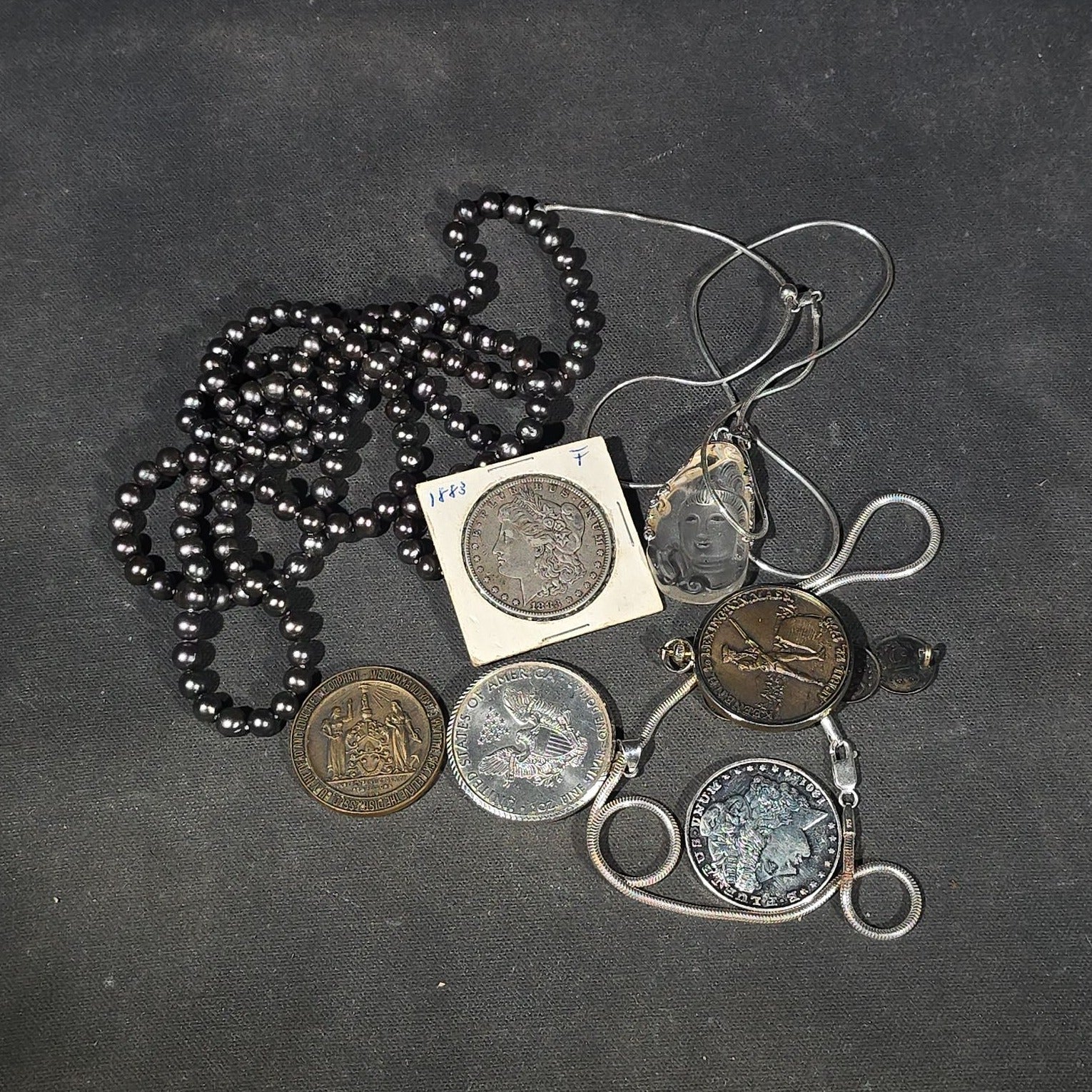 Lot 148 - Grouping of Antique and Reproduction Coins, Coin Pendants, Bead Necklaces, and Carved Pendant Including 1883 Morgan Dollar and Seated Liberty Coin Jewelry (13)
