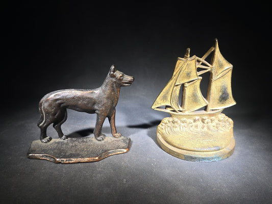 Pair of Antique Mismatched Cast Iron Bookends including a Standing Dog and a Sailing Ship, Manufactured by Bradley & Hubbard Mfg. Co., Meriden, Connecticut