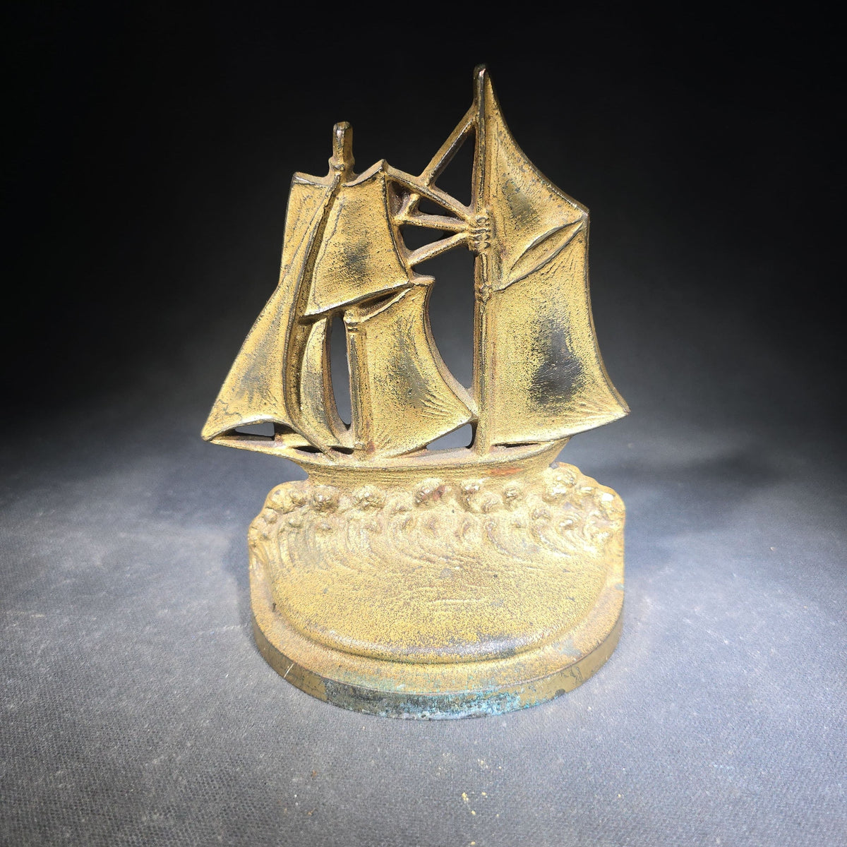 Pair of Antique Mismatched Cast Iron Bookends including a Standing Dog and a Sailing Ship, Manufactured by Bradley & Hubbard Mfg. Co., Meriden, Connecticut