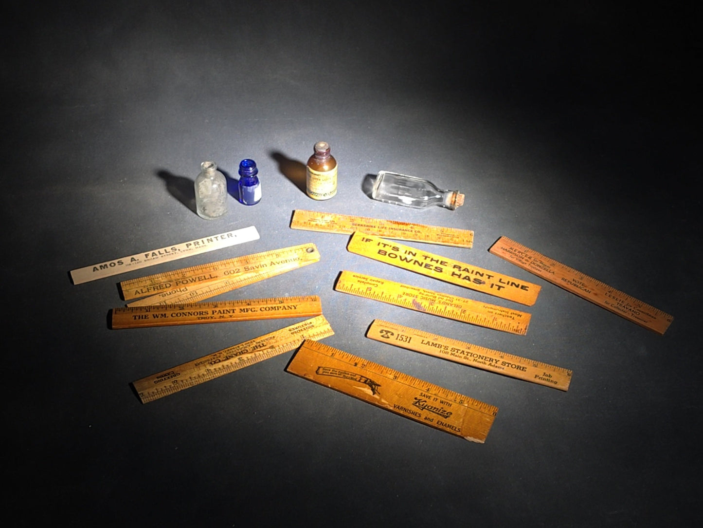 Grouping of 14 Antique and Vintage Smalls including 10 Wooden Advertising Rulers and Four Small Glass Bottles