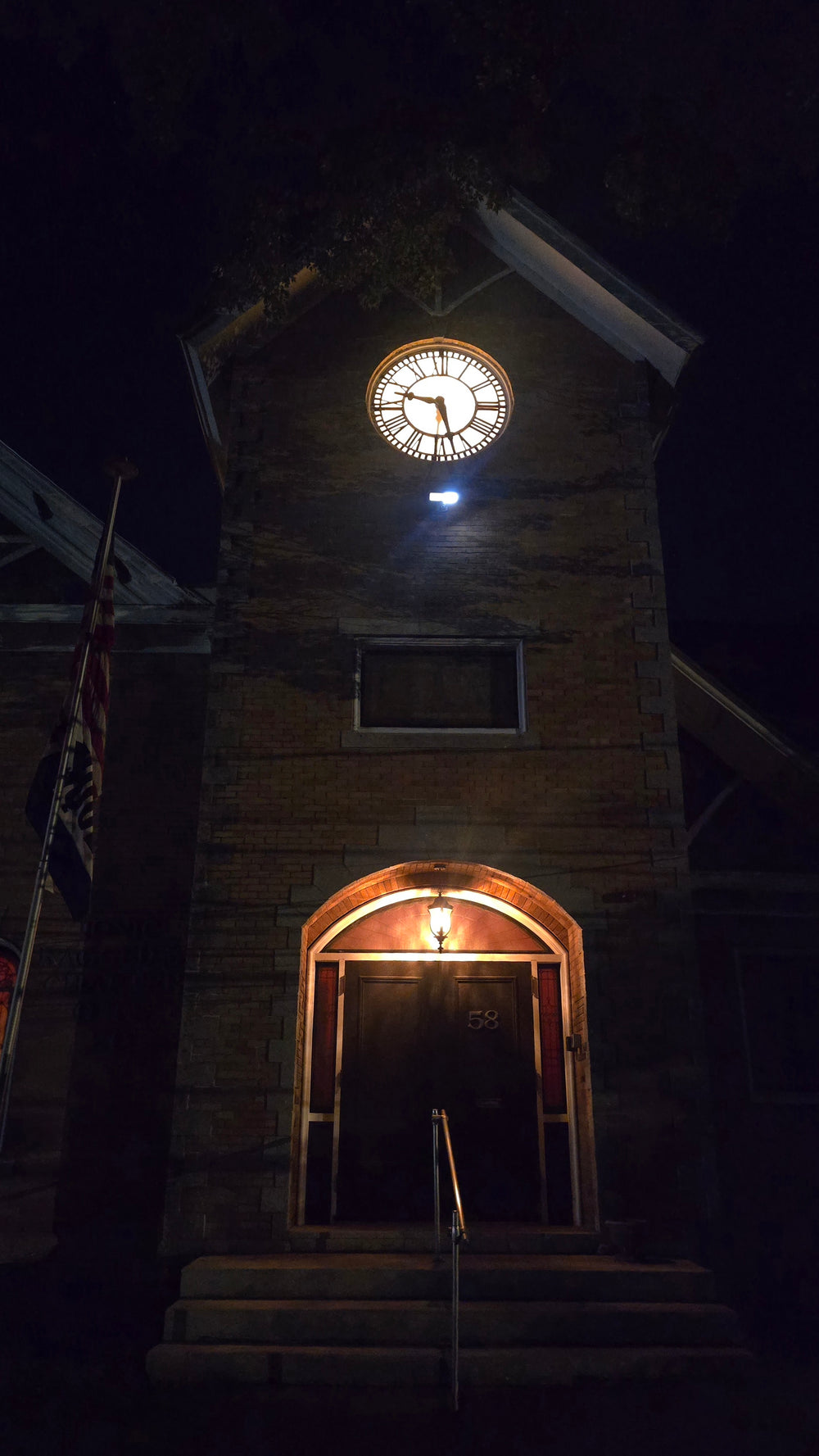 The lit clock tower at 58 South Main Street at night