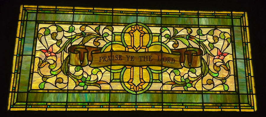 Window in the organ room reading Praise Ye the Lord