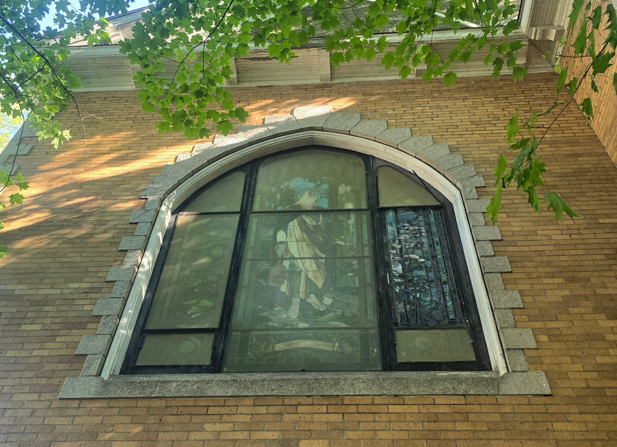 A main-hall window still walled over inside, seen from outside